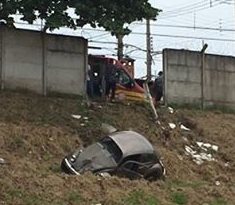 Fusca derruba muro e cai em barranco